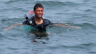 Ceuta Migrant boy swims to shore with plastic bottles tied to himself [upl. by Lleryd929]