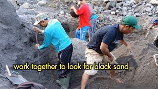 The manual miners work together to collect black sand they sift the sand to separate the rocks [upl. by Duarte]