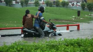 Man tries to drive through flooded water on bike but fails portly wife sits on [upl. by Amesari]