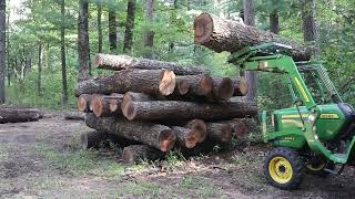 John Deere 3025e Stacking Logs [upl. by Kawai]