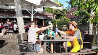 Happy friends clinking of glasses of beer drinks in beach cafe at beautiful sunset View from drone [upl. by Rayham]