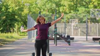 Woman is standing and stretching on outdoor workout area in the park at summer day [upl. by Eserrehs727]