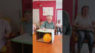 Players push long pins through a cardboard box attempting to pop the balloon [upl. by Ellata160]