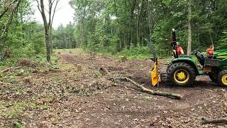 John Deere 3025e pulling out tree tops [upl. by Willie]